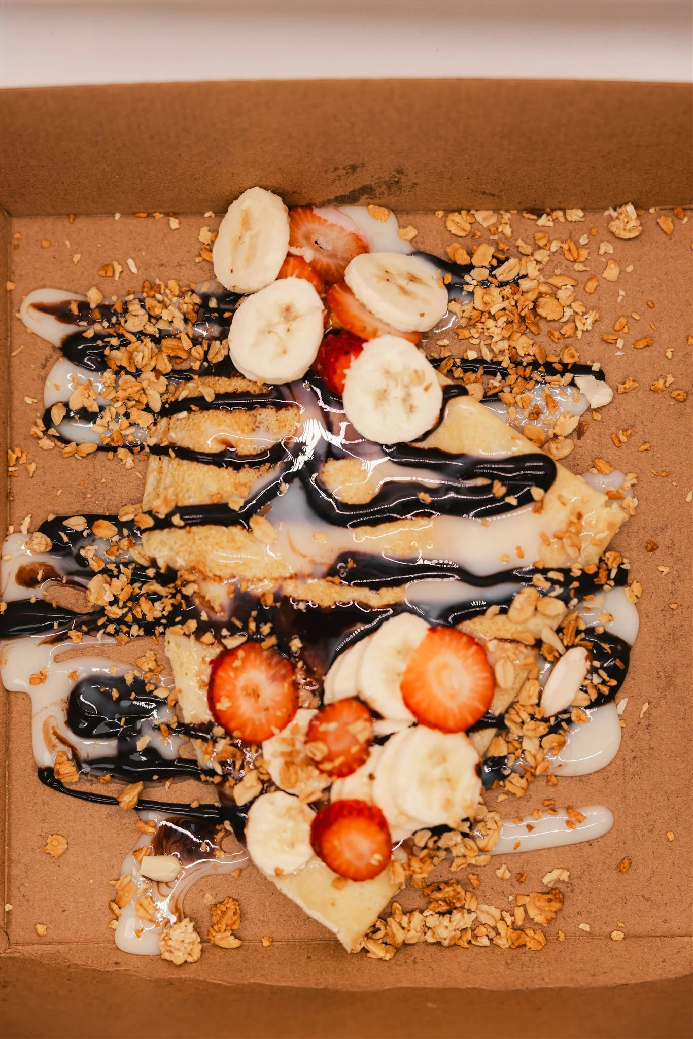 Delicious dessert crepes topped with fruits and chocolate sauce
