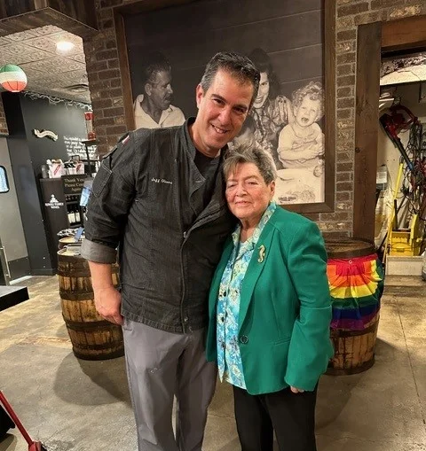 Chef posing with a guest in a cozy restaurant setting