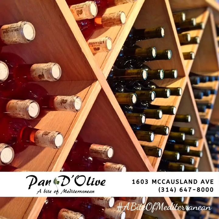 A wooden wine rack filled with various bottles of wine, showcasing a mix of colors and labels.