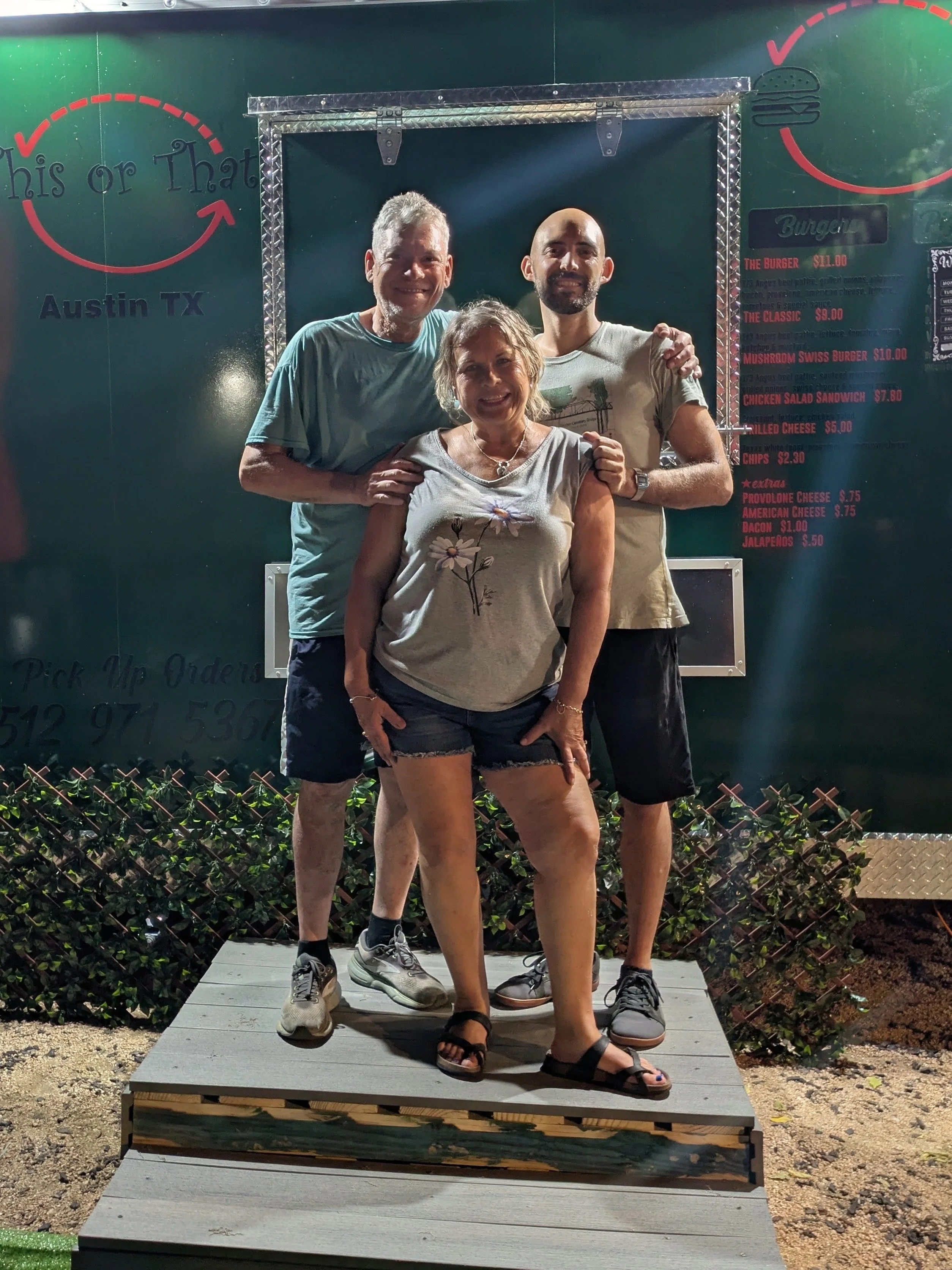 Three people posing outside a burger restaurant in Austin, Texas