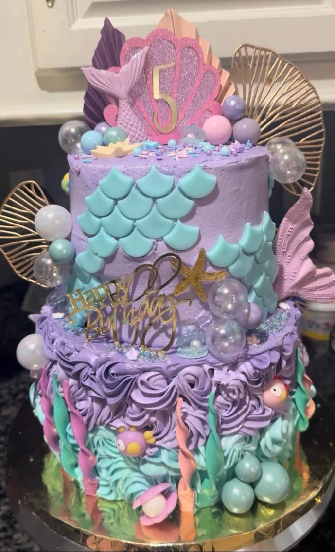 Colorful mermaid-themed birthday cake with decorative elements and vibrant colors