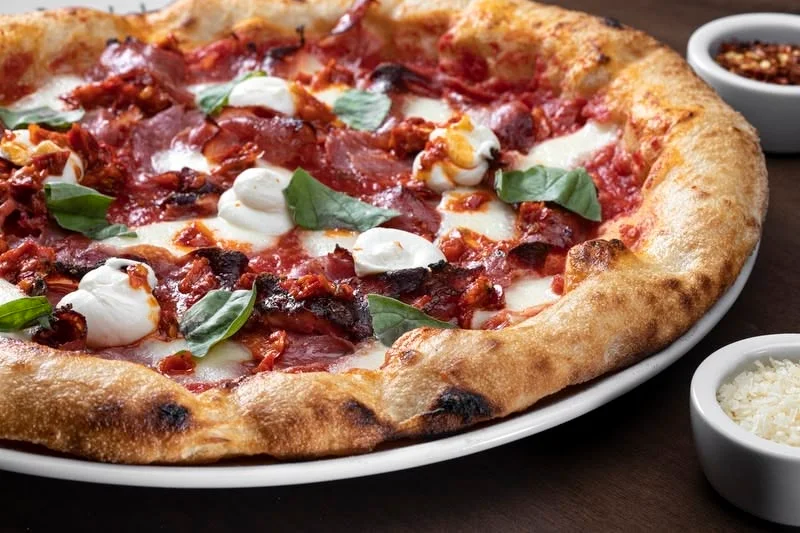Delicious pepperoni pizza with fresh basil and creamy dollops