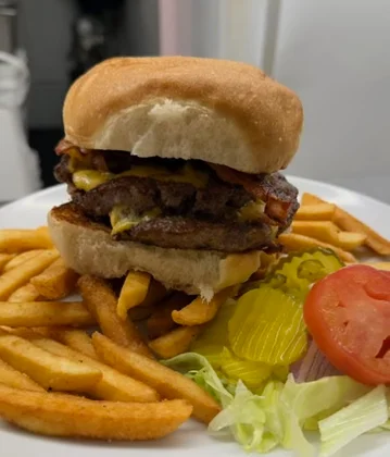 Juicy cheeseburger with fries on a plate