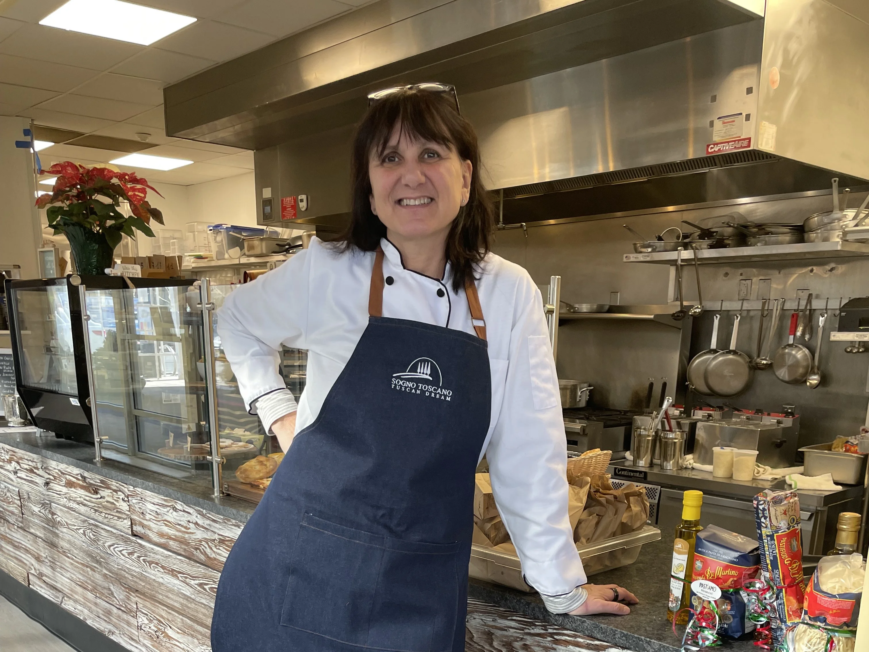 Chef in a cozy restaurant kitchen with a welcoming smile
