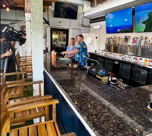 Bartender preparing drinks at a vibrant bar with multiple taps