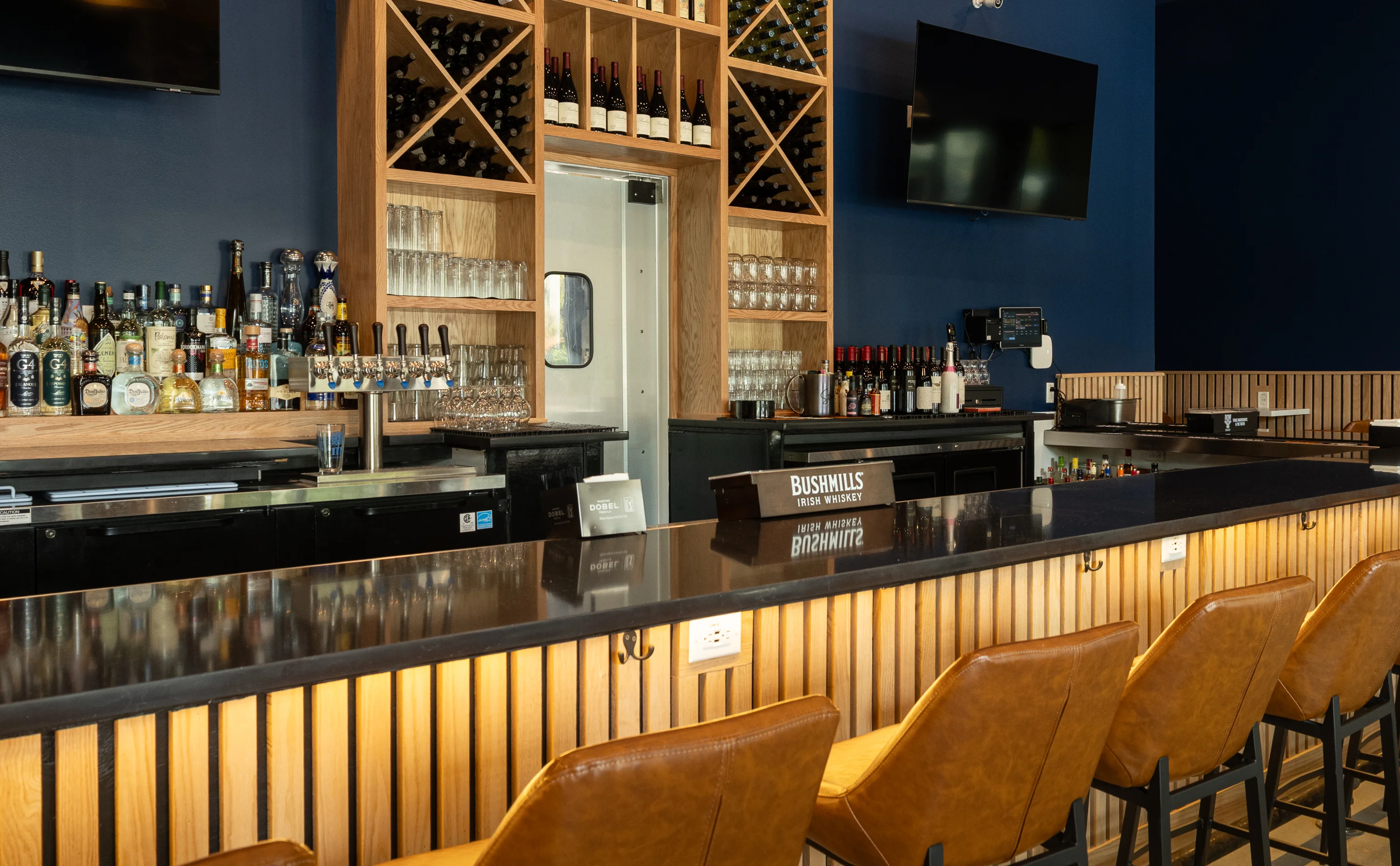Modern bar interior with a sleek counter and diverse liquor selection