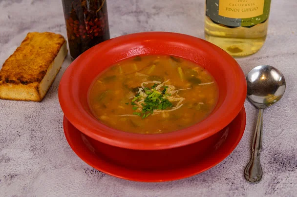 Hearty bowl of Mexican pozole garnished with fresh herbs