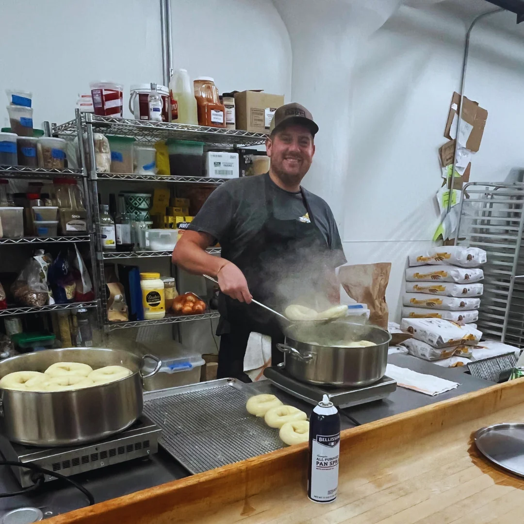 Chef preparing fresh bagels in a bustling kitchen