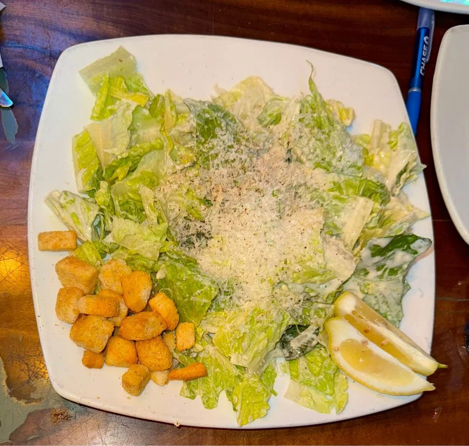 Classic Caesar salad with croutons and lemon wedges