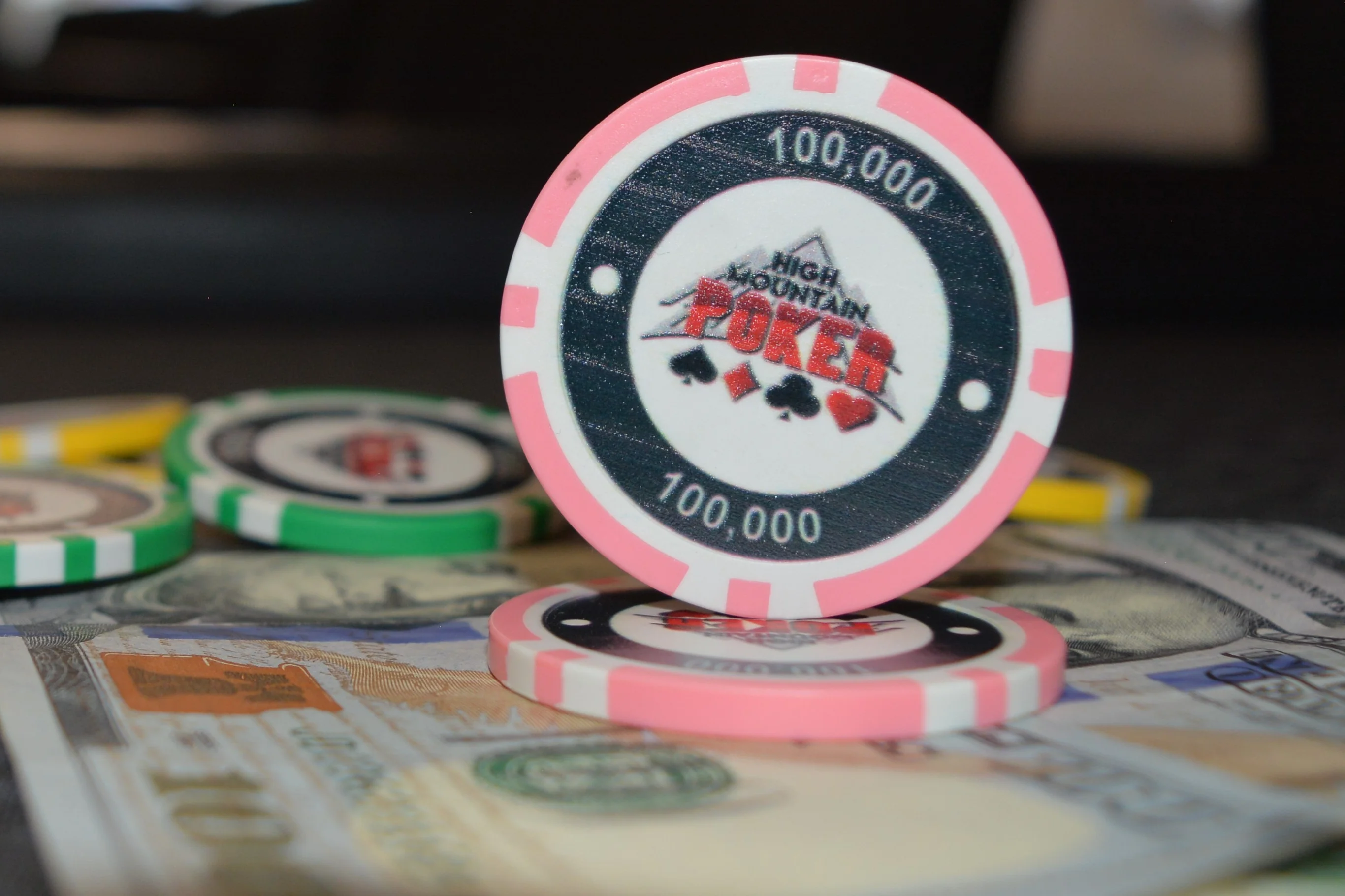 Colorful poker chips stacked on cash