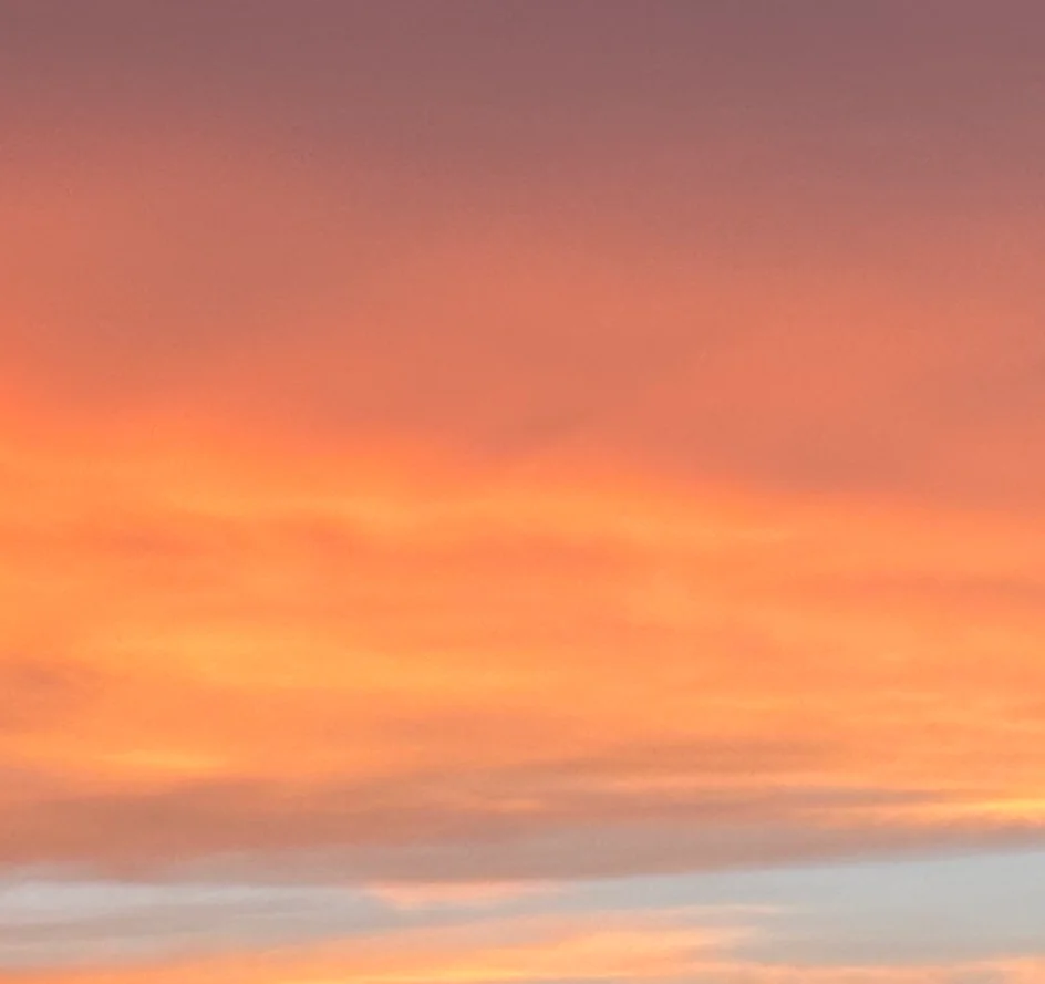 Vibrant sunset over a foggy landscape with colorful clouds
