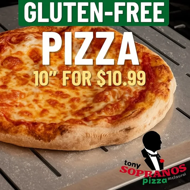 A close-up of a gluten-free pizza featuring melted cheese on a golden crust, displayed on a metal tray.