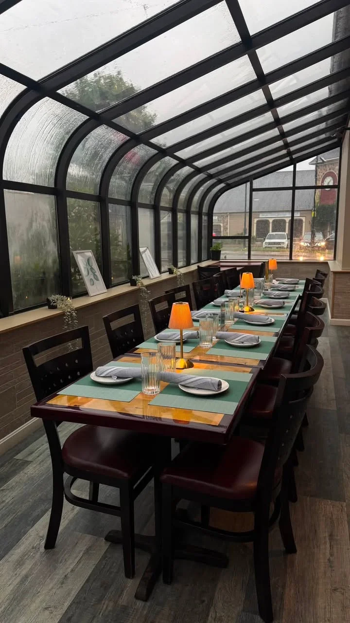 Cozy restaurant dining area with glass roof and warm lighting