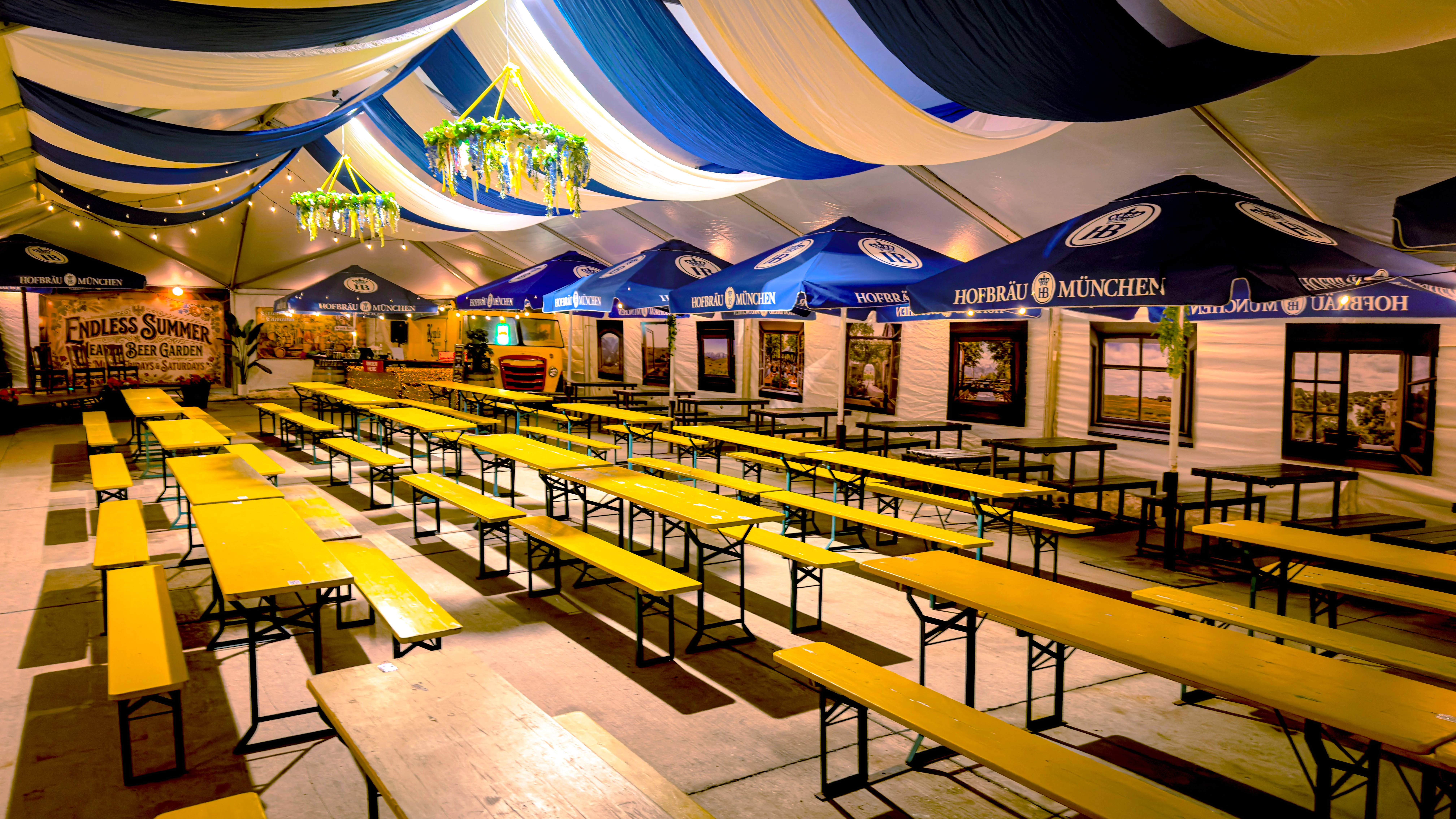 Spacious beer garden with yellow tables and festive decor