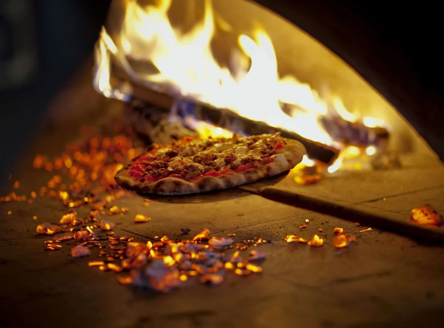 Wood-fired Margherita pizza baking in a traditional oven