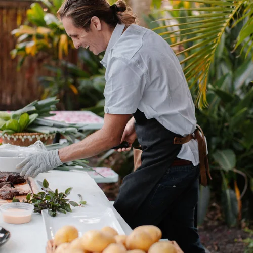Chef preparing dishes in a tropical outdoor setting