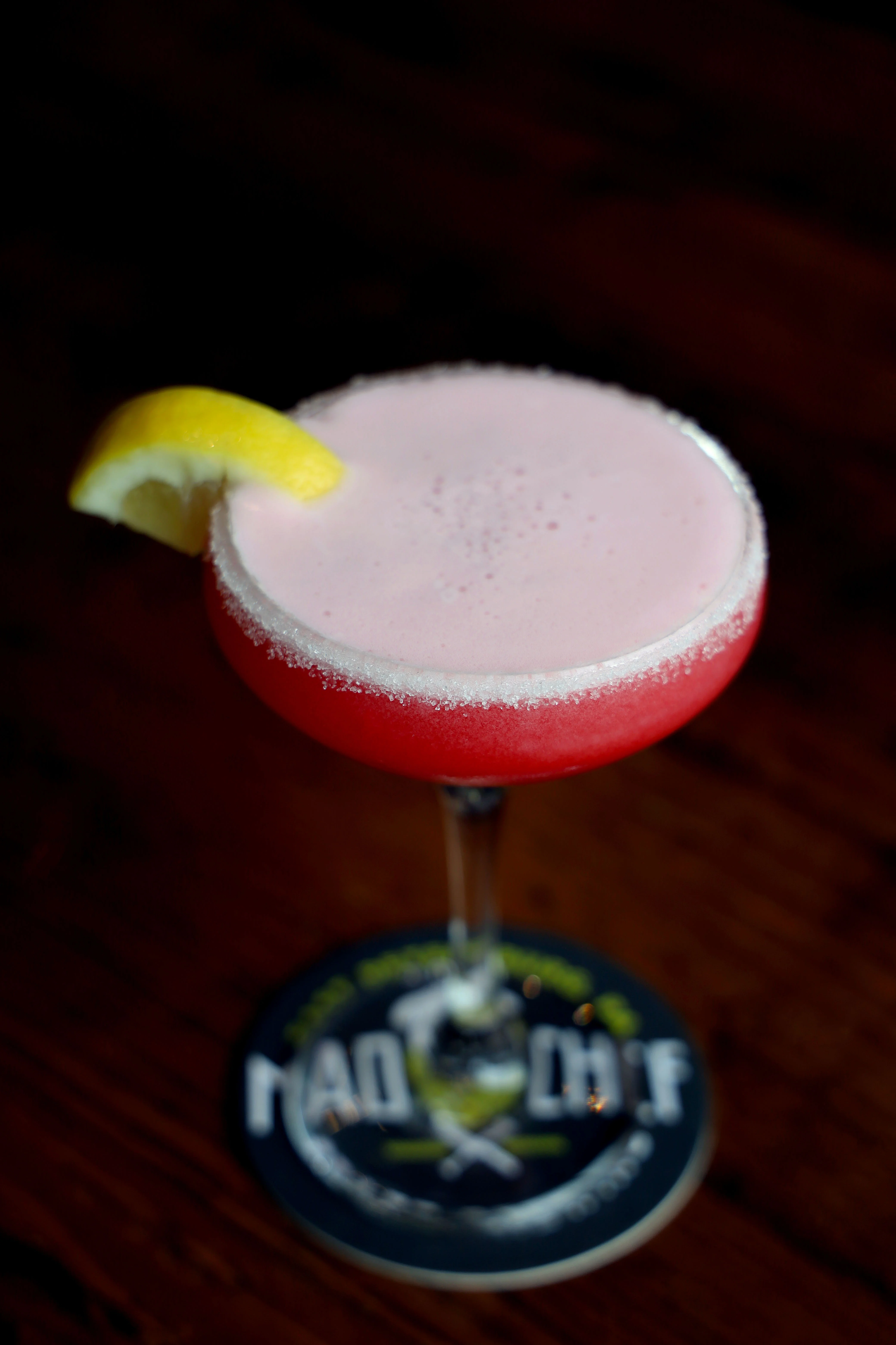 Refreshing pink cocktail with lemon garnish