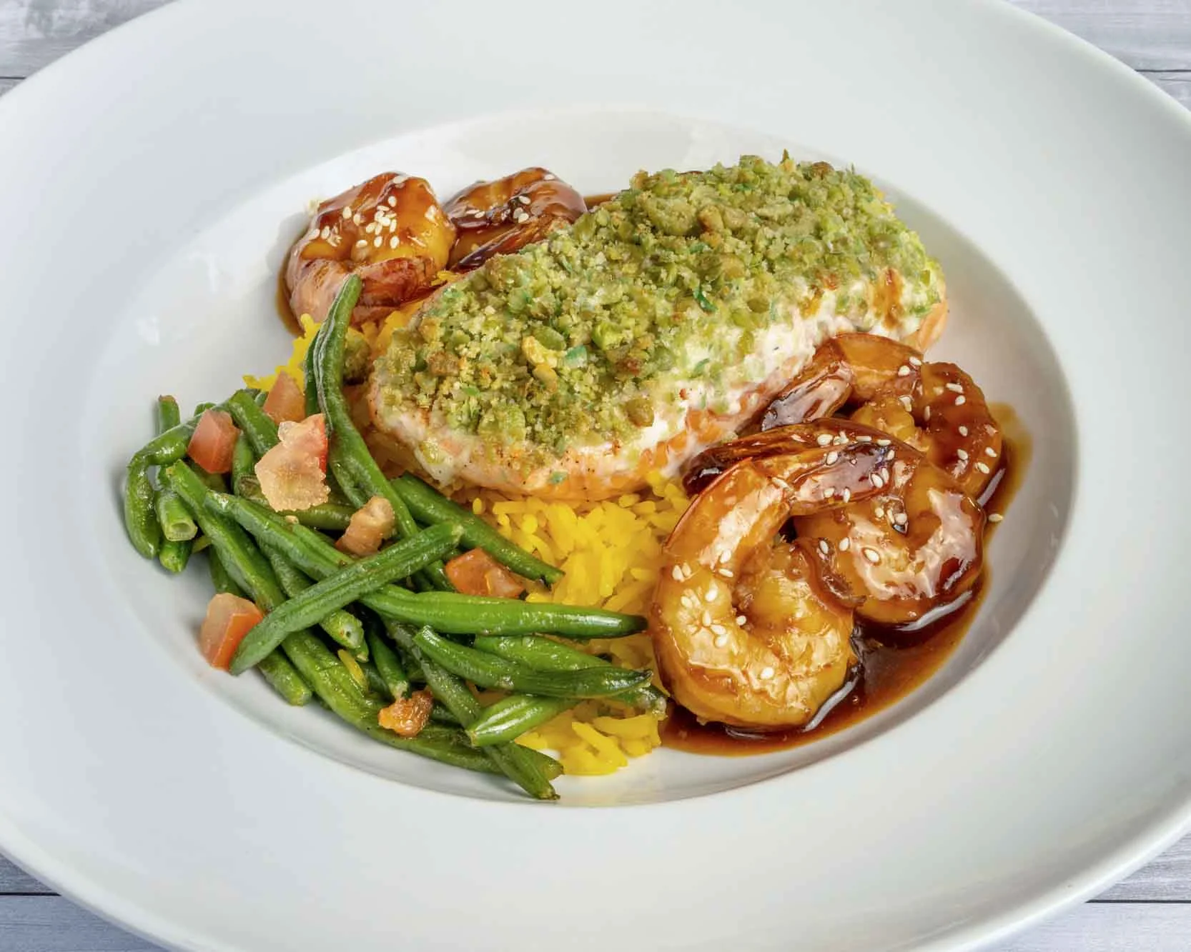 Baked salmon with shrimp and green beans on saffron rice