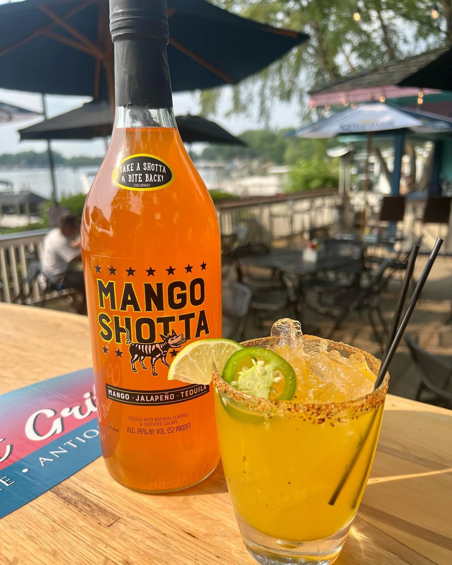 Mango cocktail on the patio with Bluff Lake behind it