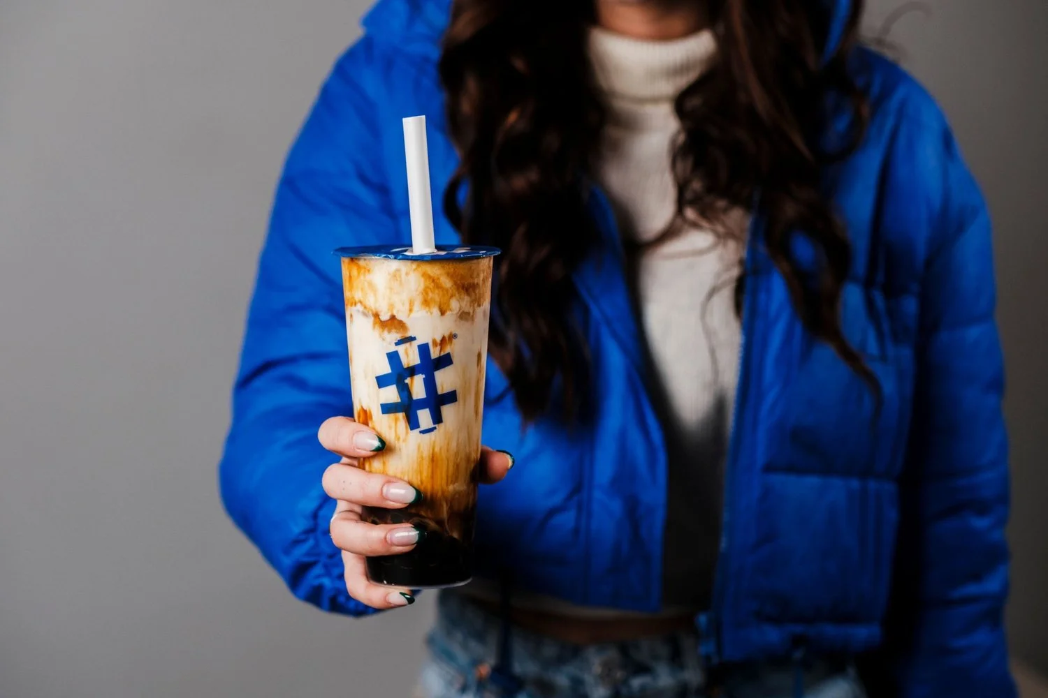 Colorful bubble tea in a stylish cup with a blue jacket background