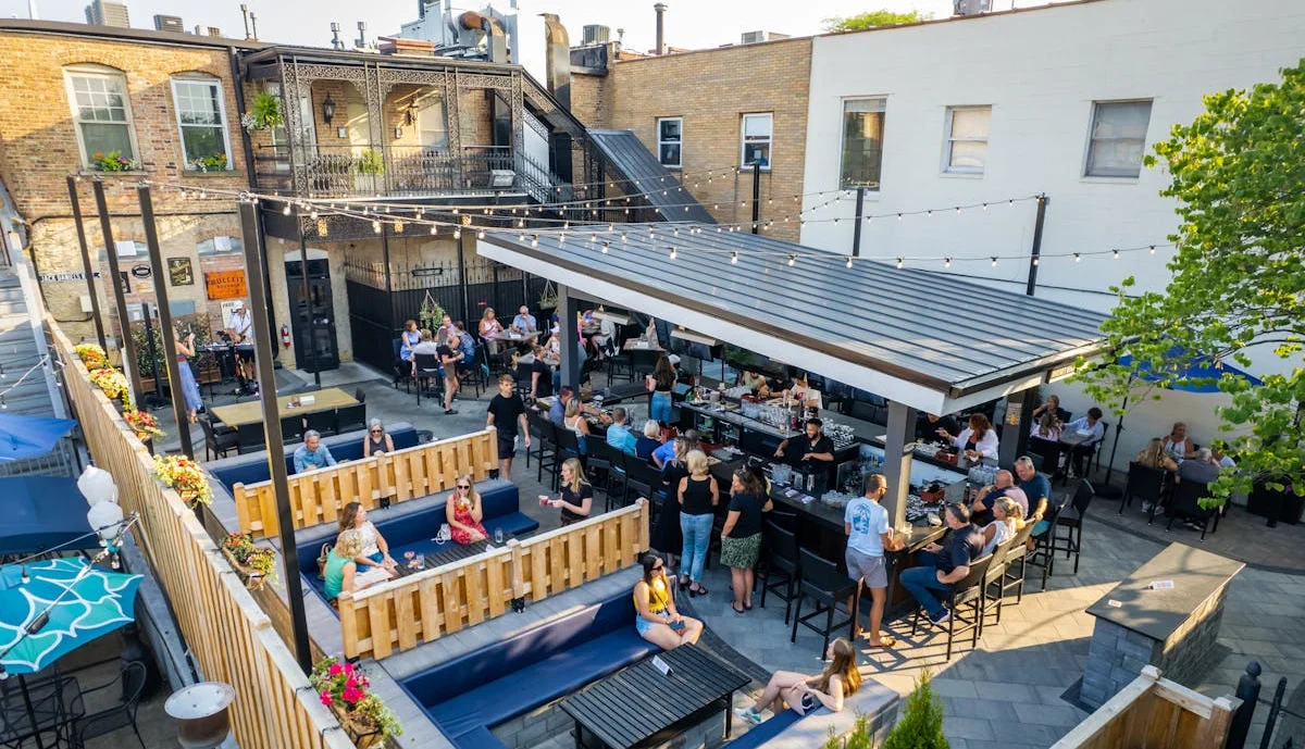 Outdoor dining area with patrons enjoying drinks and food