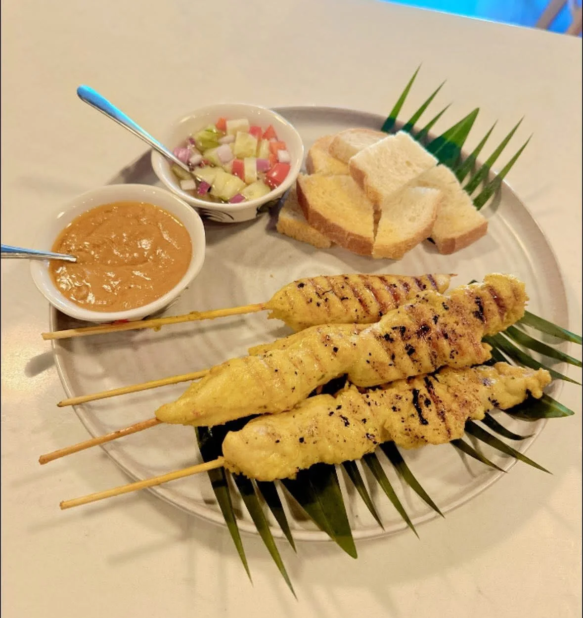 Indonesian satay skewers with peanut sauce and fresh salad