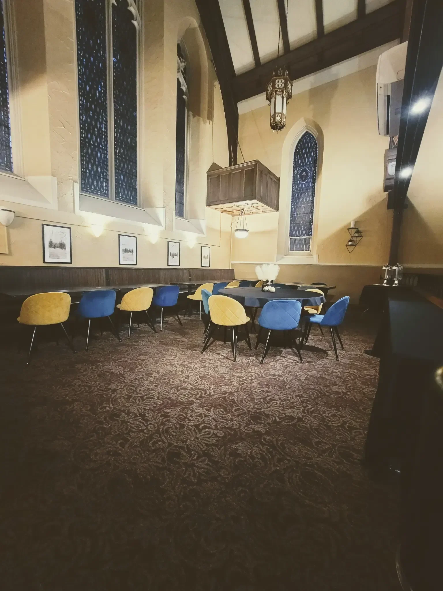 Cozy restaurant interior with colorful chairs and stained glass windows