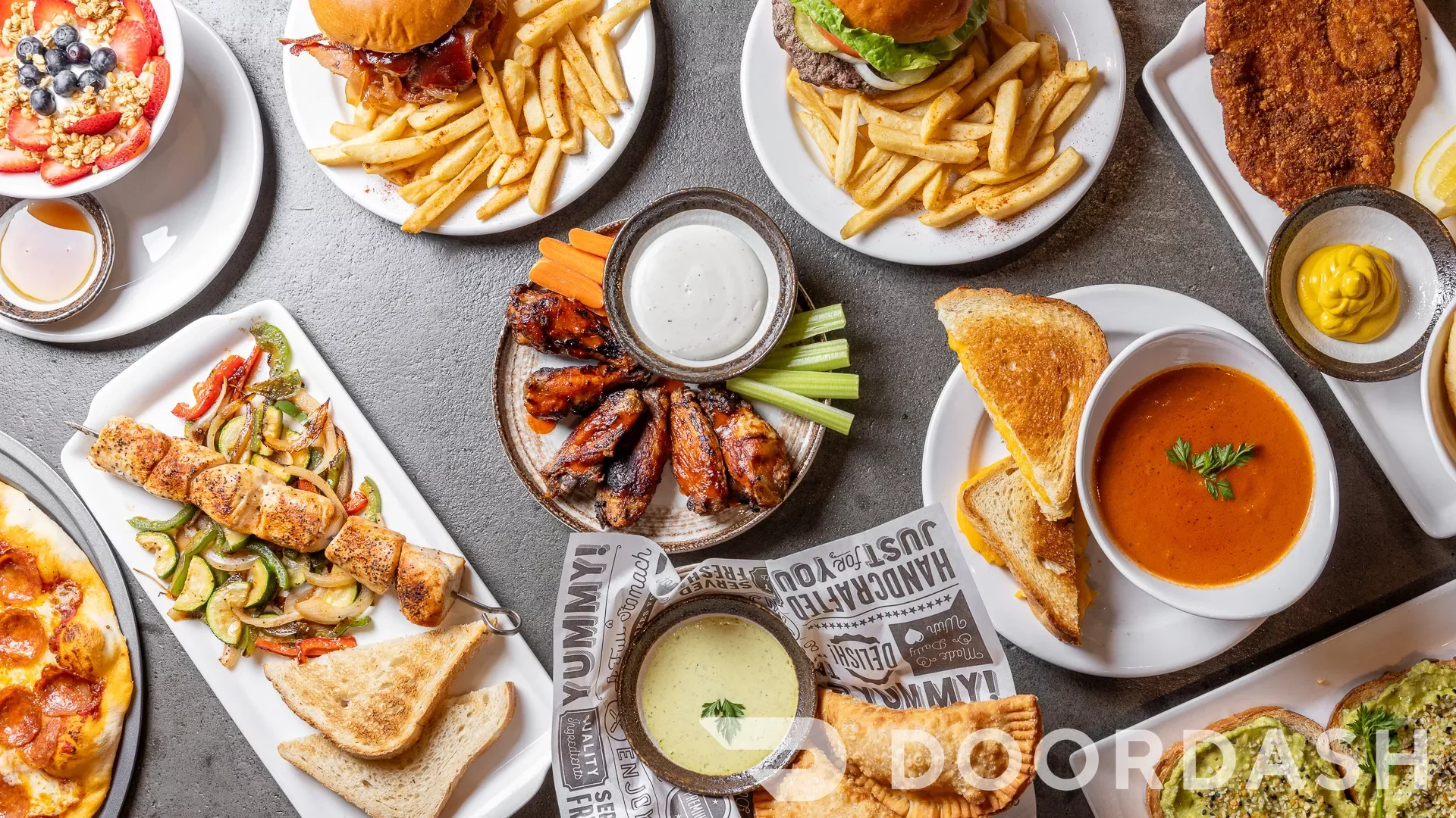 Assorted American comfort food platter with wings, burgers, and soup