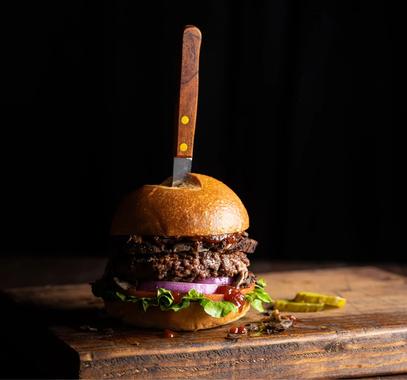 Juicy American cheeseburger with a knife on top
