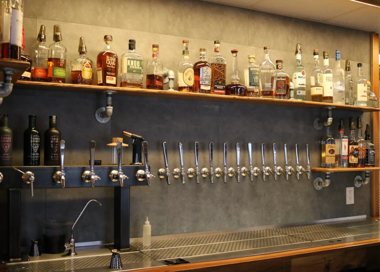 Well-stocked bar with various spirits and draft beer taps