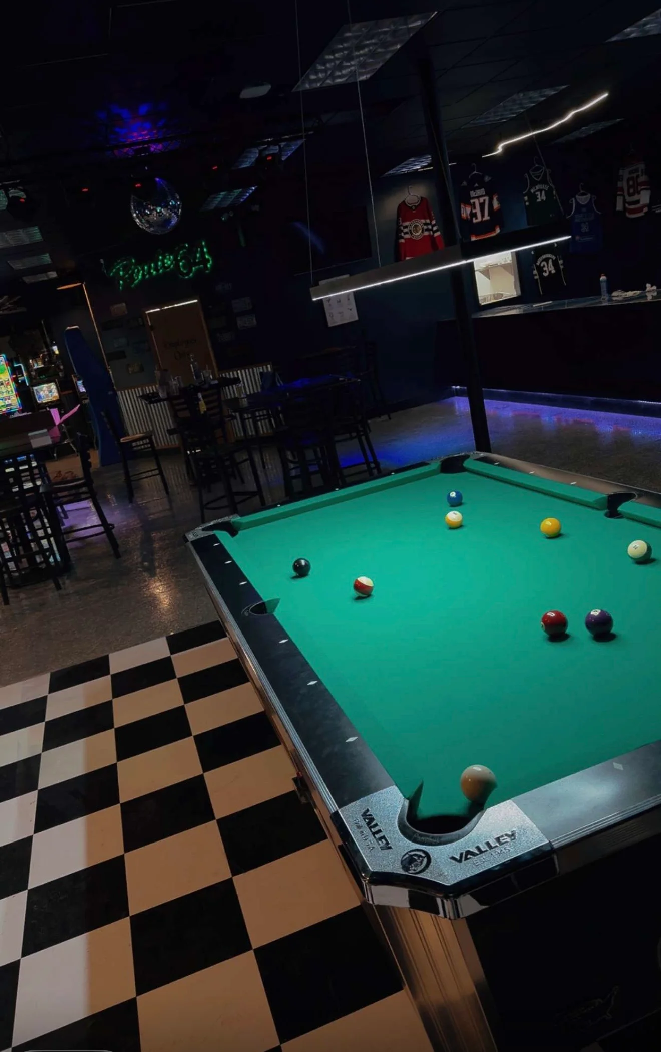 Pool table in a vibrant bar with checkered floor