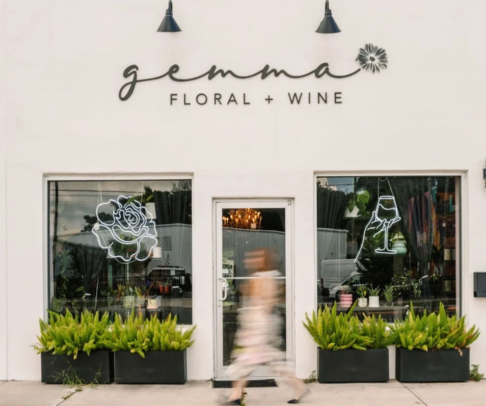 Charming floral and wine shop exterior with neon signs