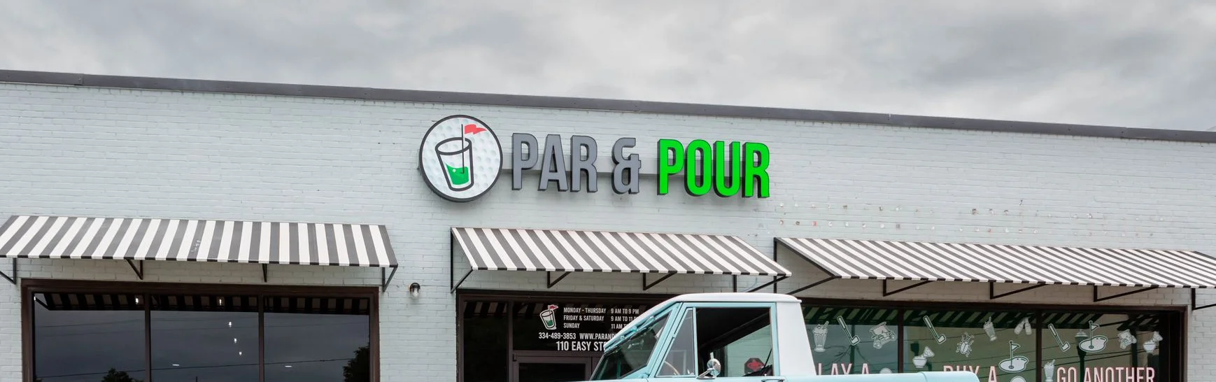 Exterior view of Par & Pour restaurant with striped awnings