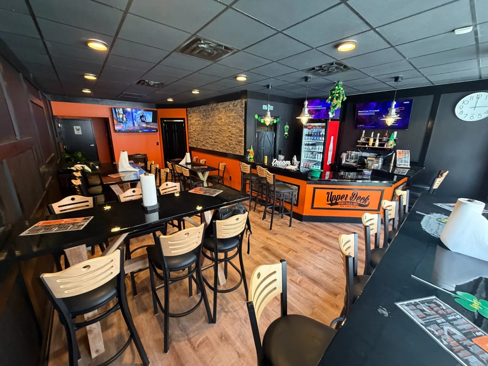 Busy restaurant dining room filled with guests and televisions