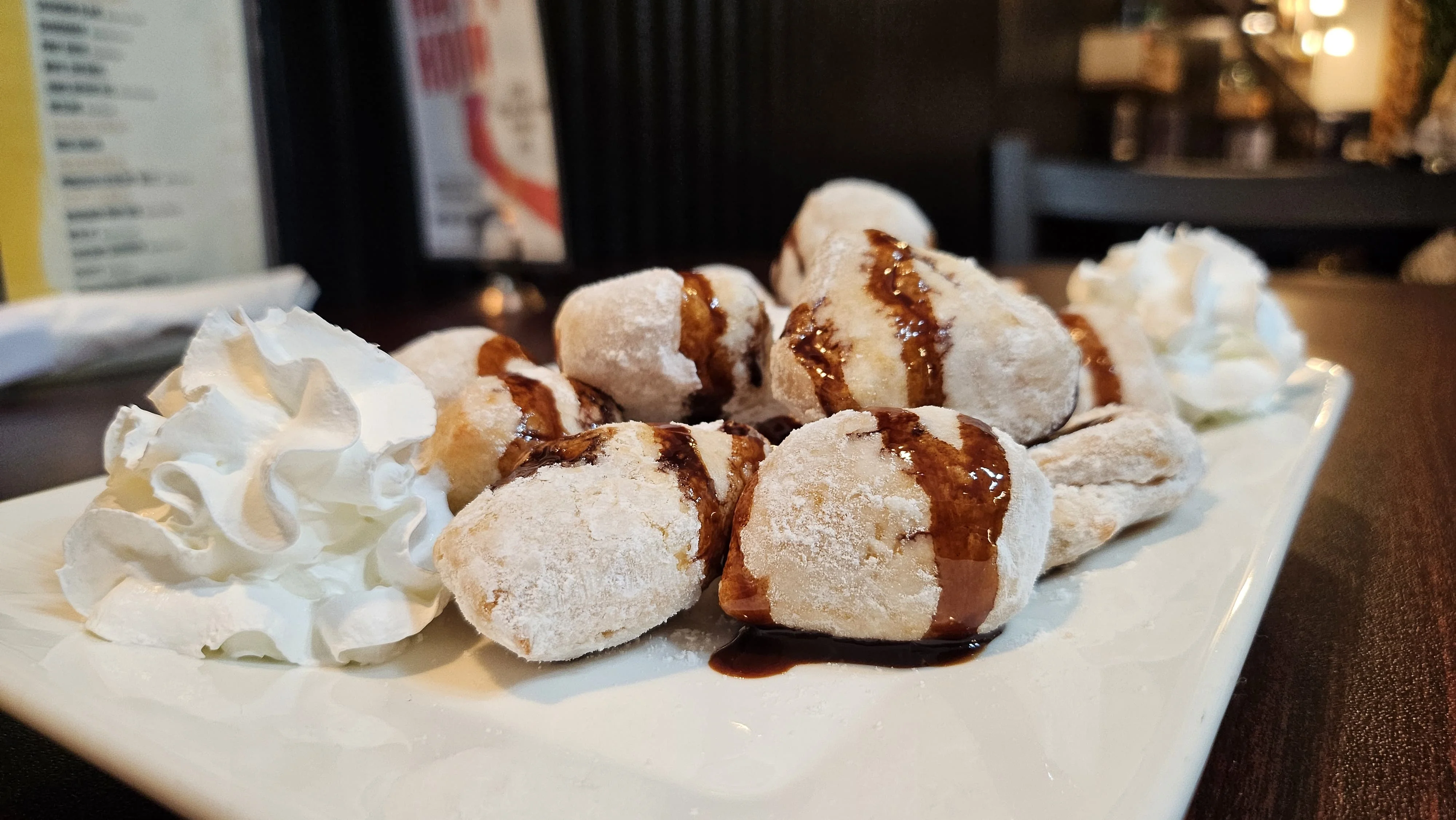 Delicious beignets drizzled with chocolate sauce and whipped cream