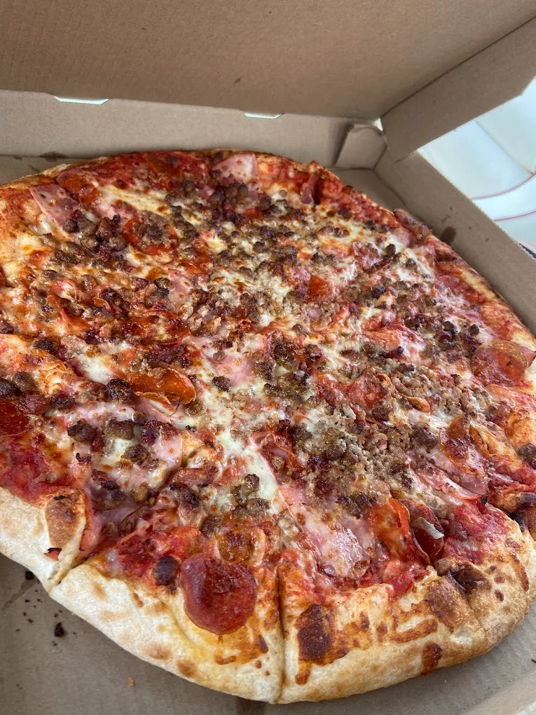 Loaded meat lover's pizza in a pizza box