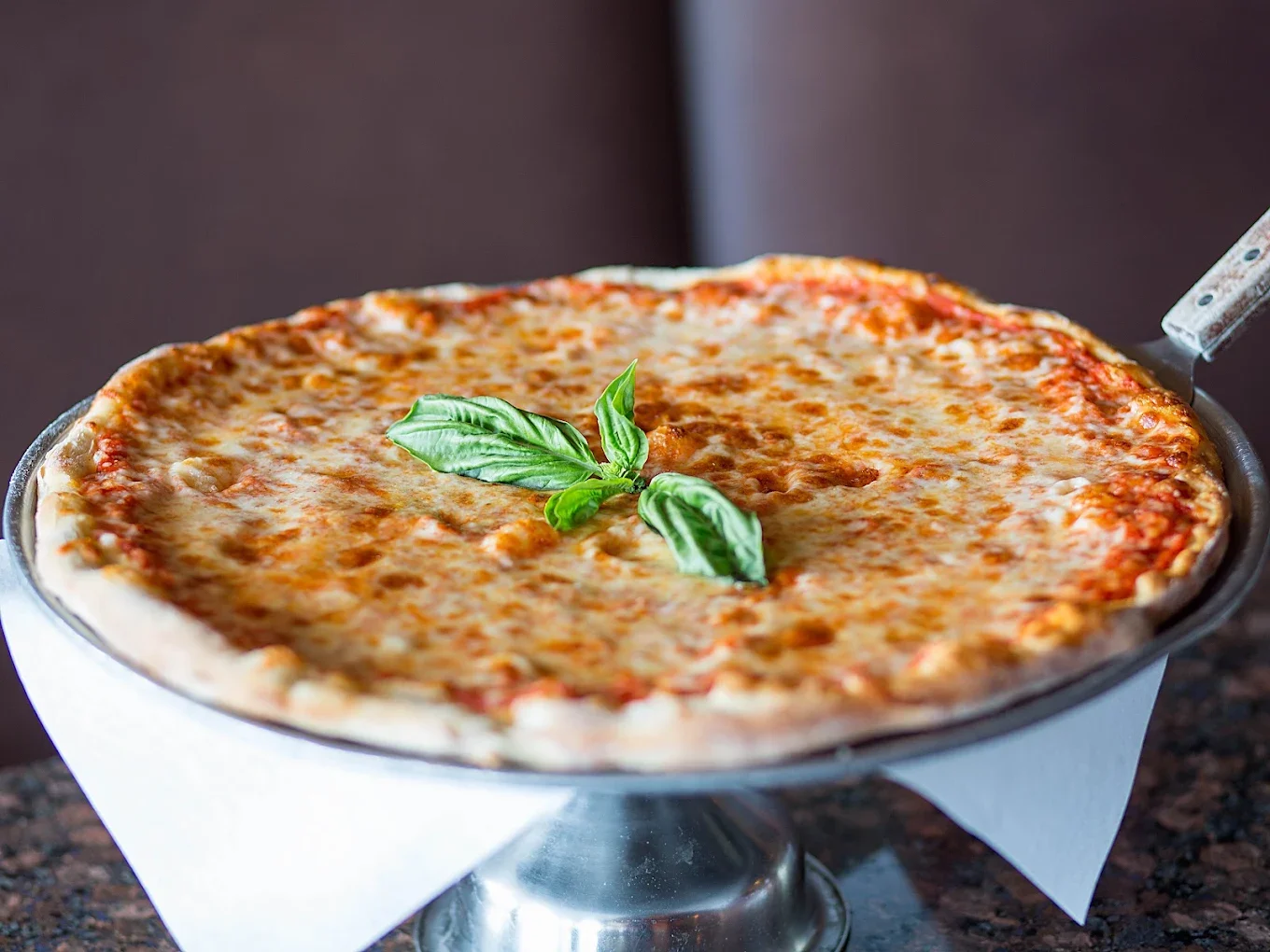 Thin-crust pepperoni pizza with melted mozzarella cheese and fresh herbs