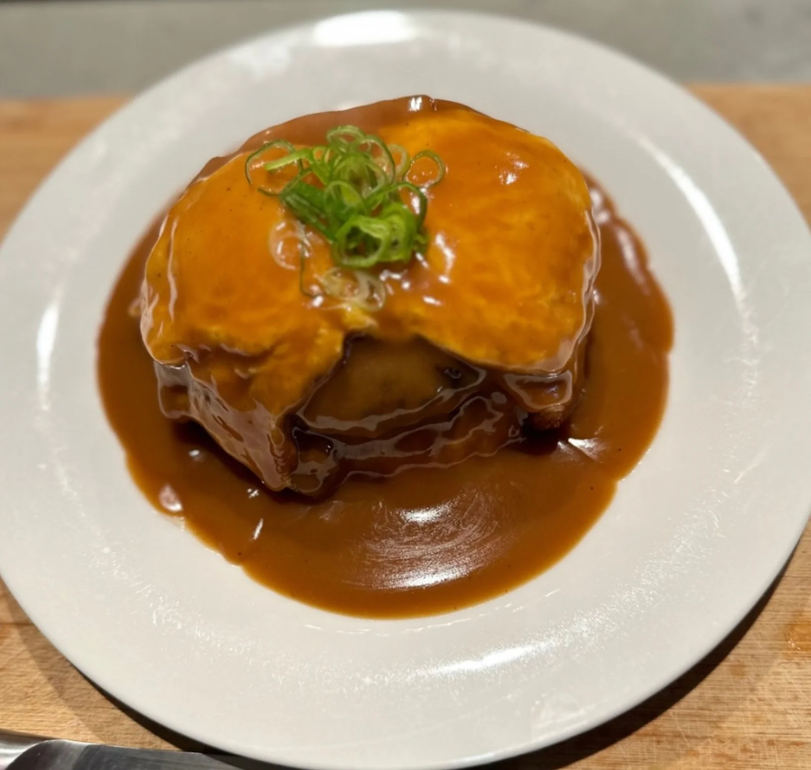 Japanese omurice topped with savory sauce and green onions
