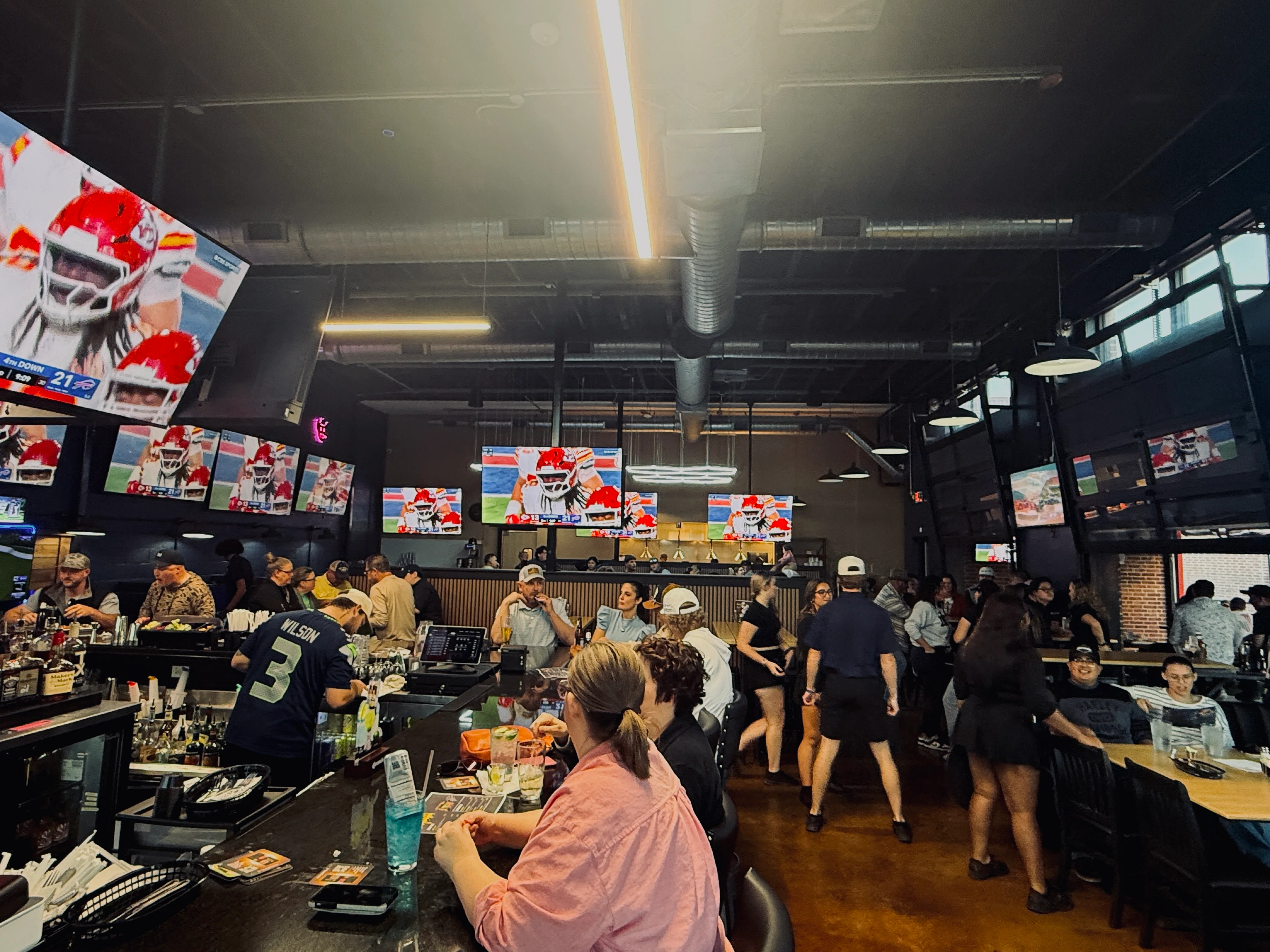 Lively sports bar interior with multiple screens showing a game