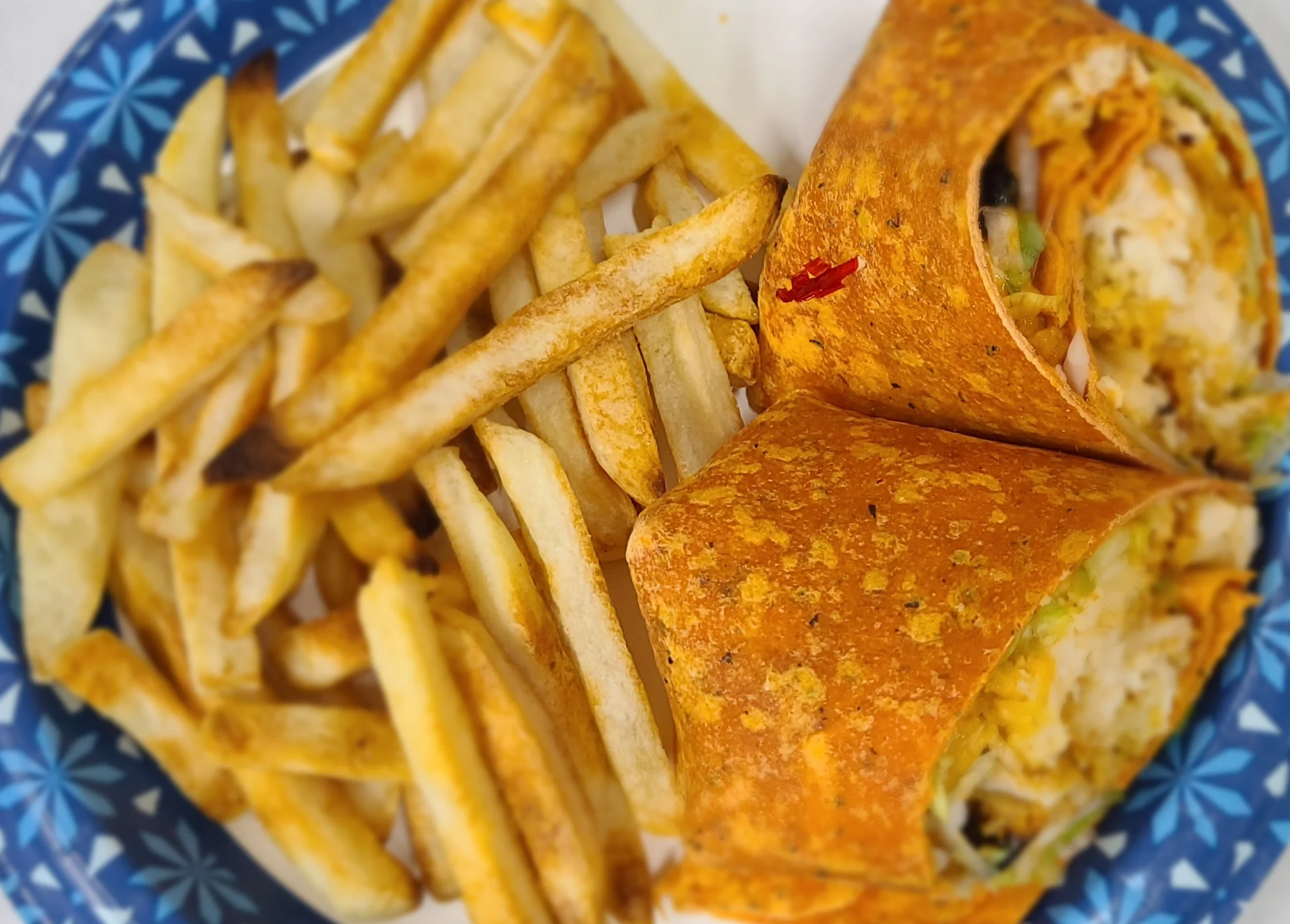 Chicken wrap with fries, showcasing a casual dining experience.