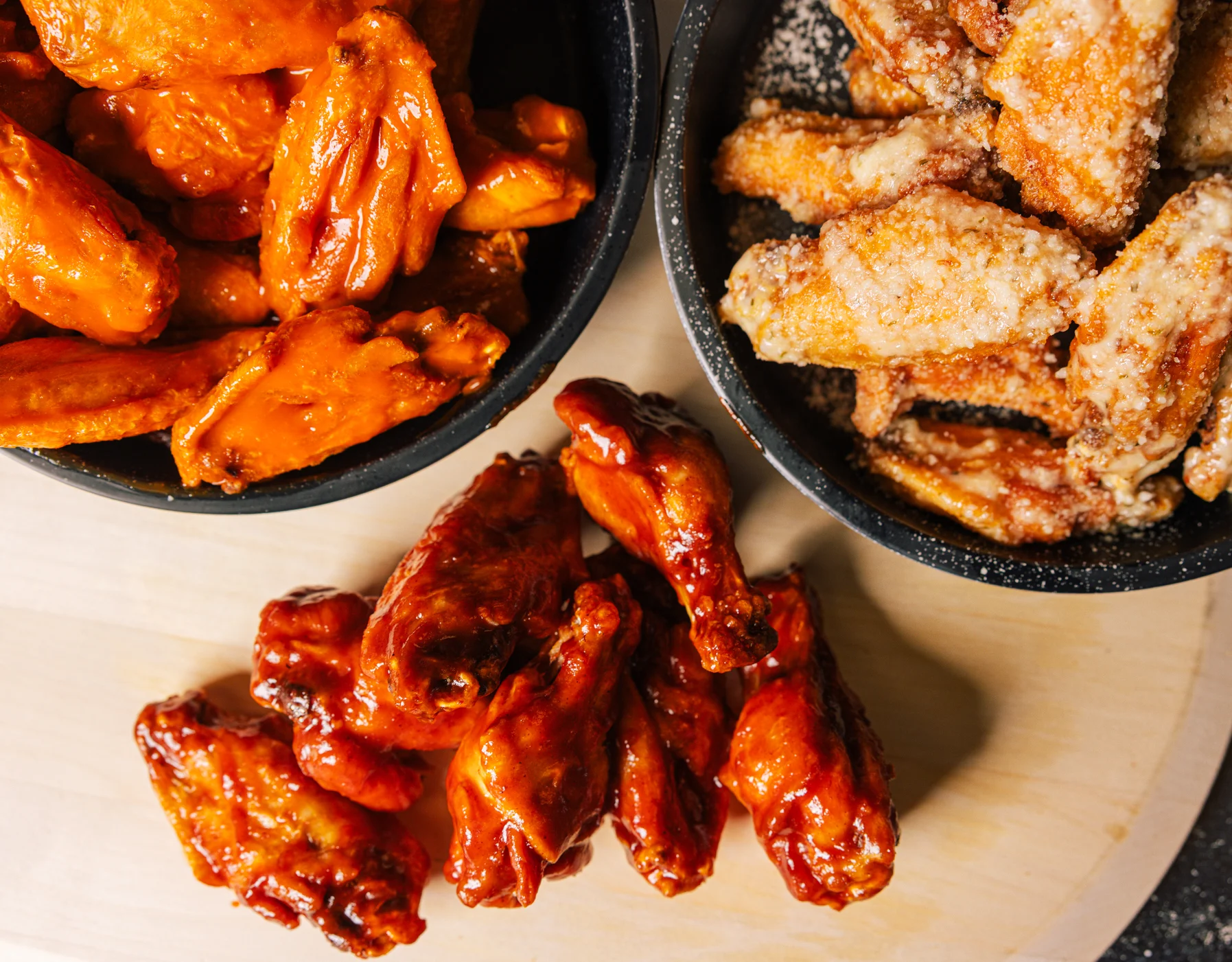 Crispy chicken wings with parmesan coating in a black bowl