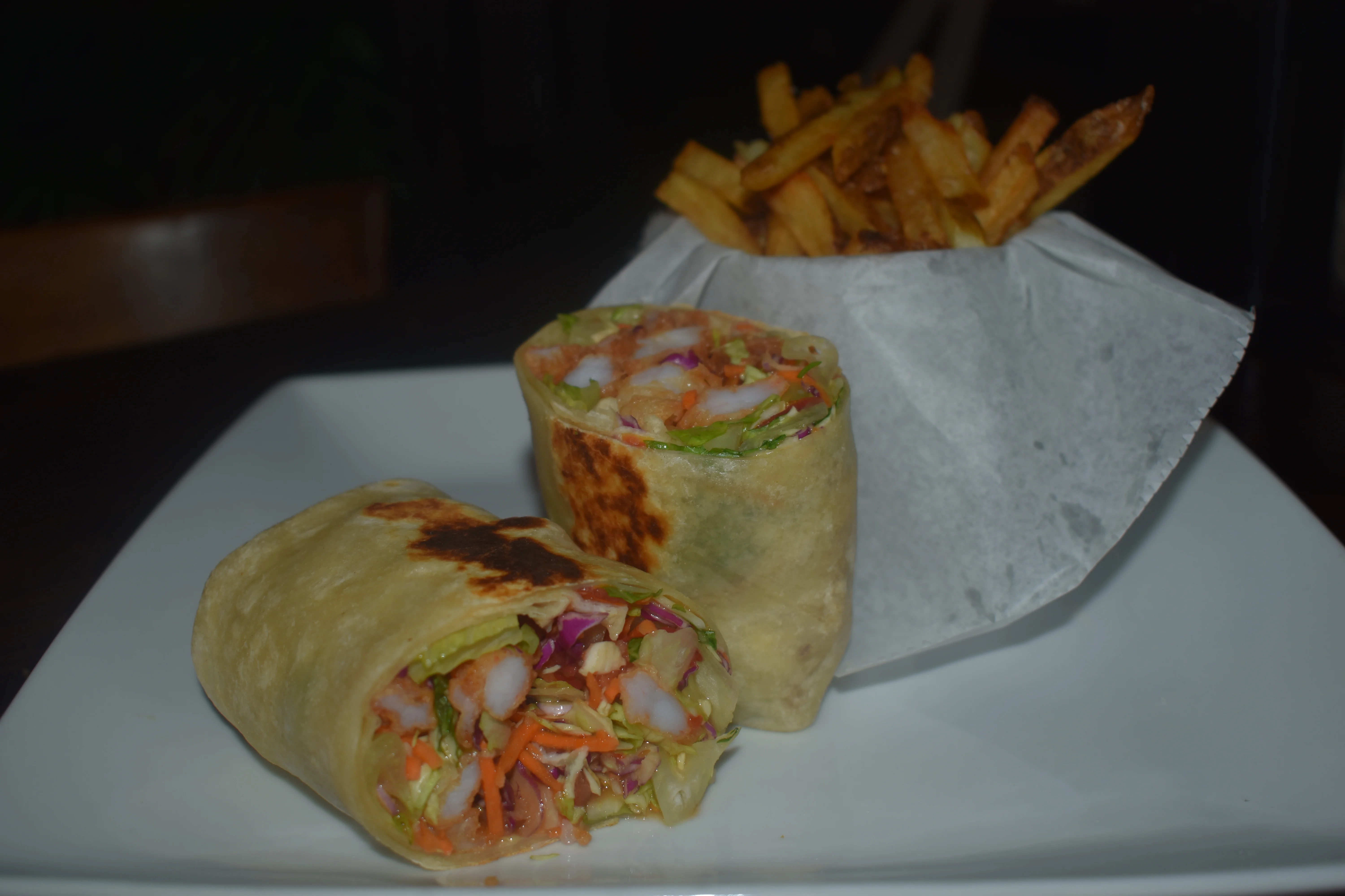 Shrimp spring rolls with fries on a plate