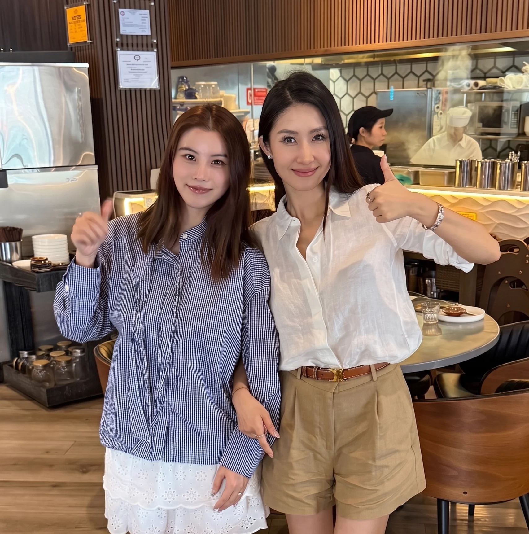 Two women posing in a modern restaurant interior