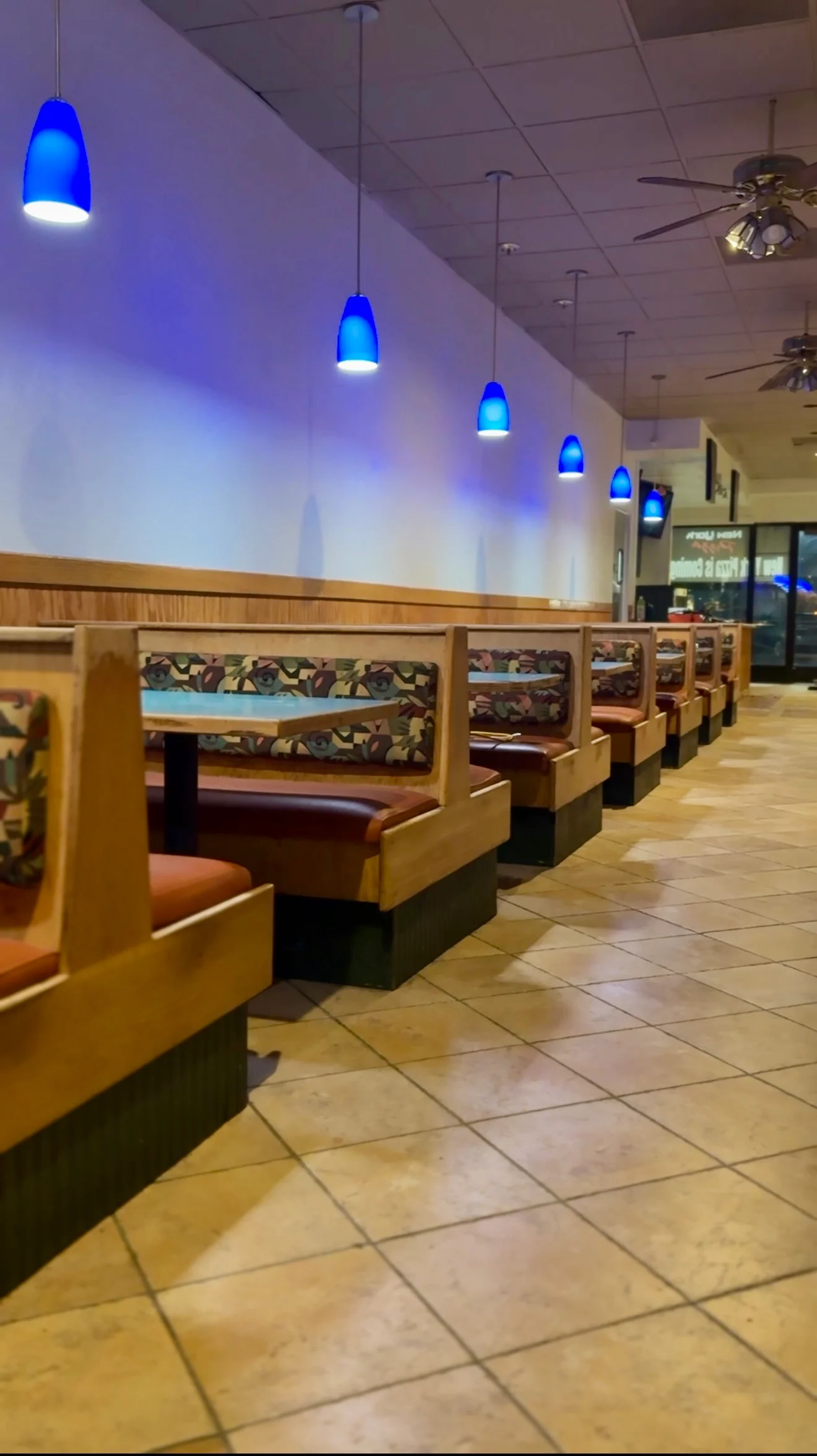 Cozy restaurant interior with blue pendant lighting and booth seating