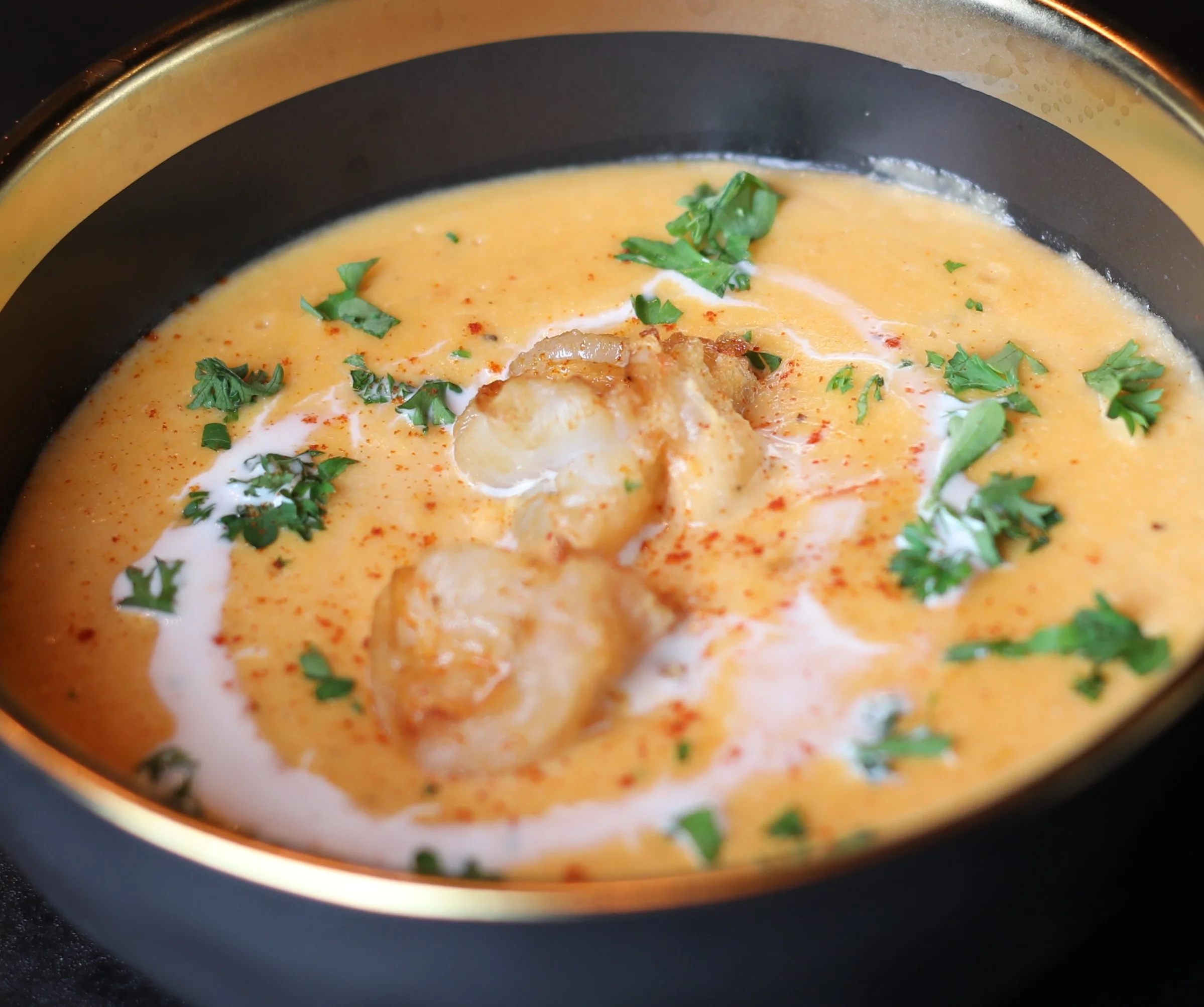 Delicious lobster soup served in a bowl with garnishes.