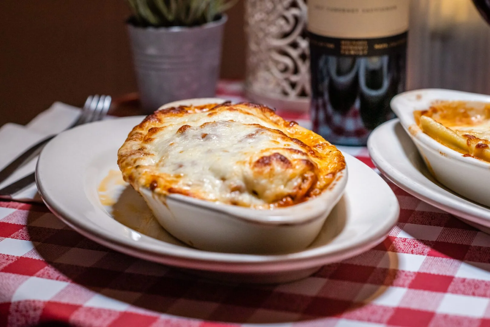 Baked lasagna with melted cheese in a cozy restaurant setting