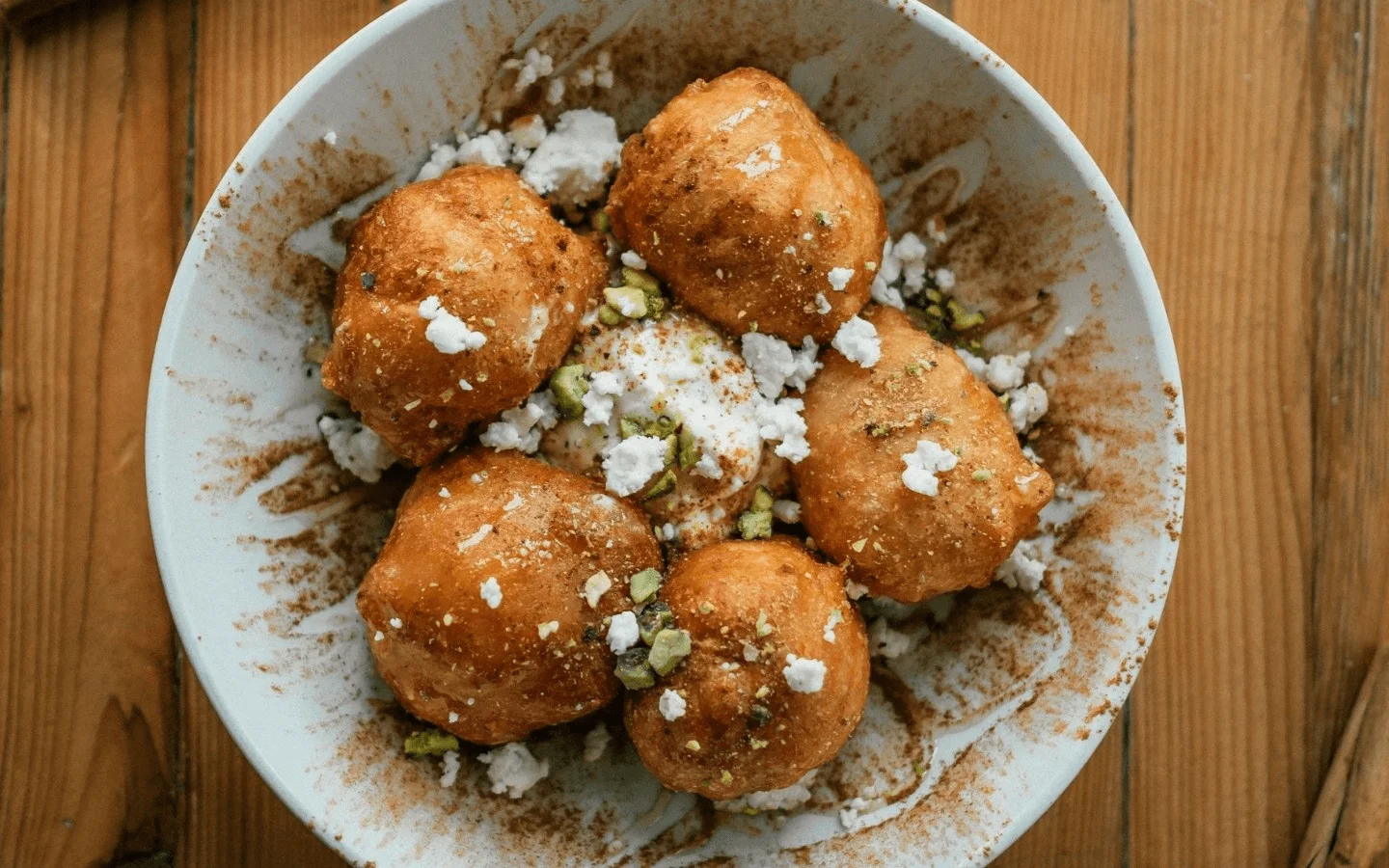 Indian gulab jamun served with nuts and cream