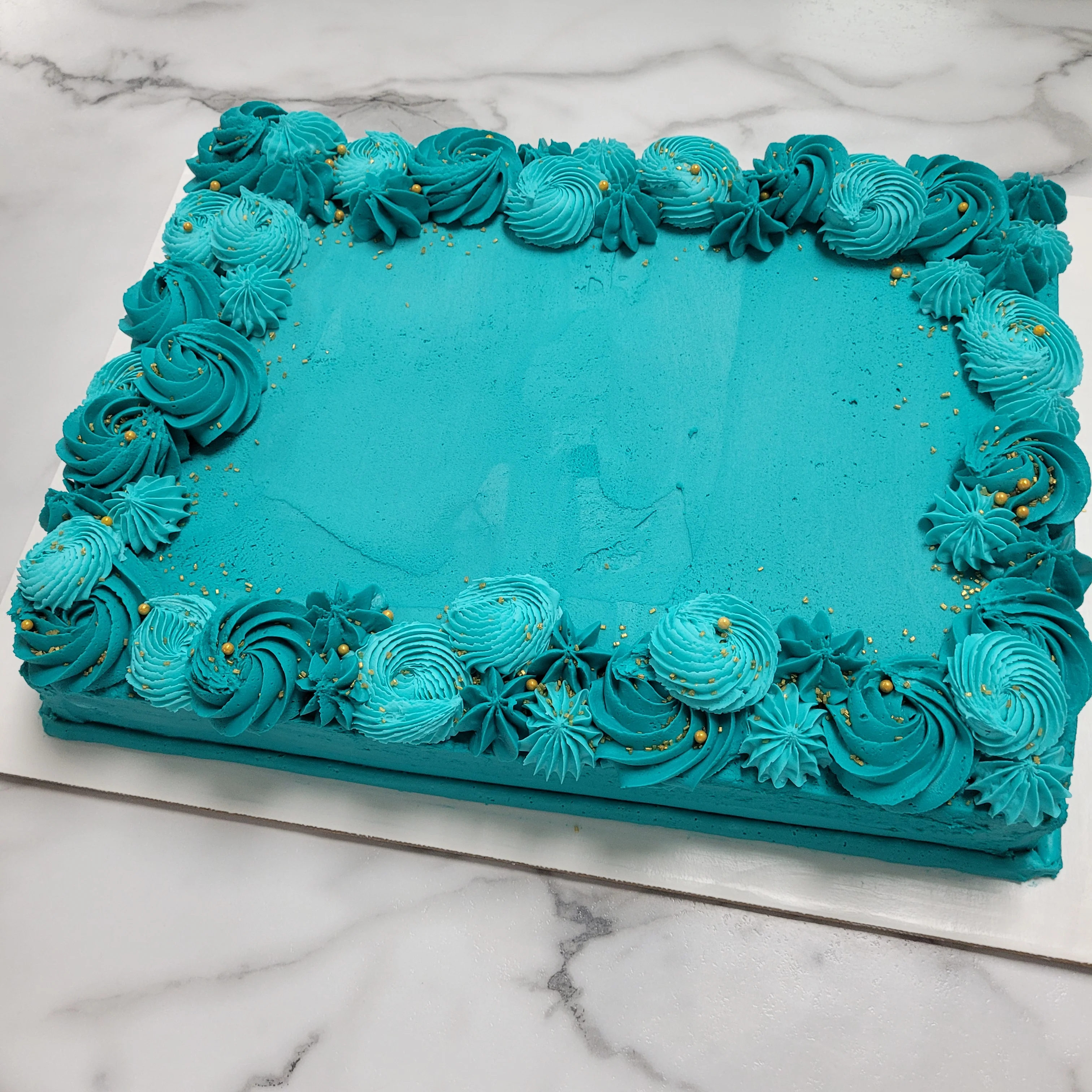 Vibrant turquoise birthday cake with decorative frosting