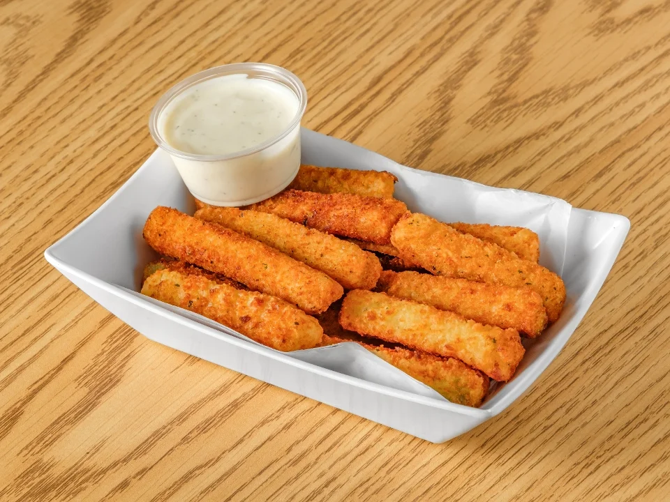 A tray filled with crispy fried cheese sticks served with a side of ranch dipping sauce.