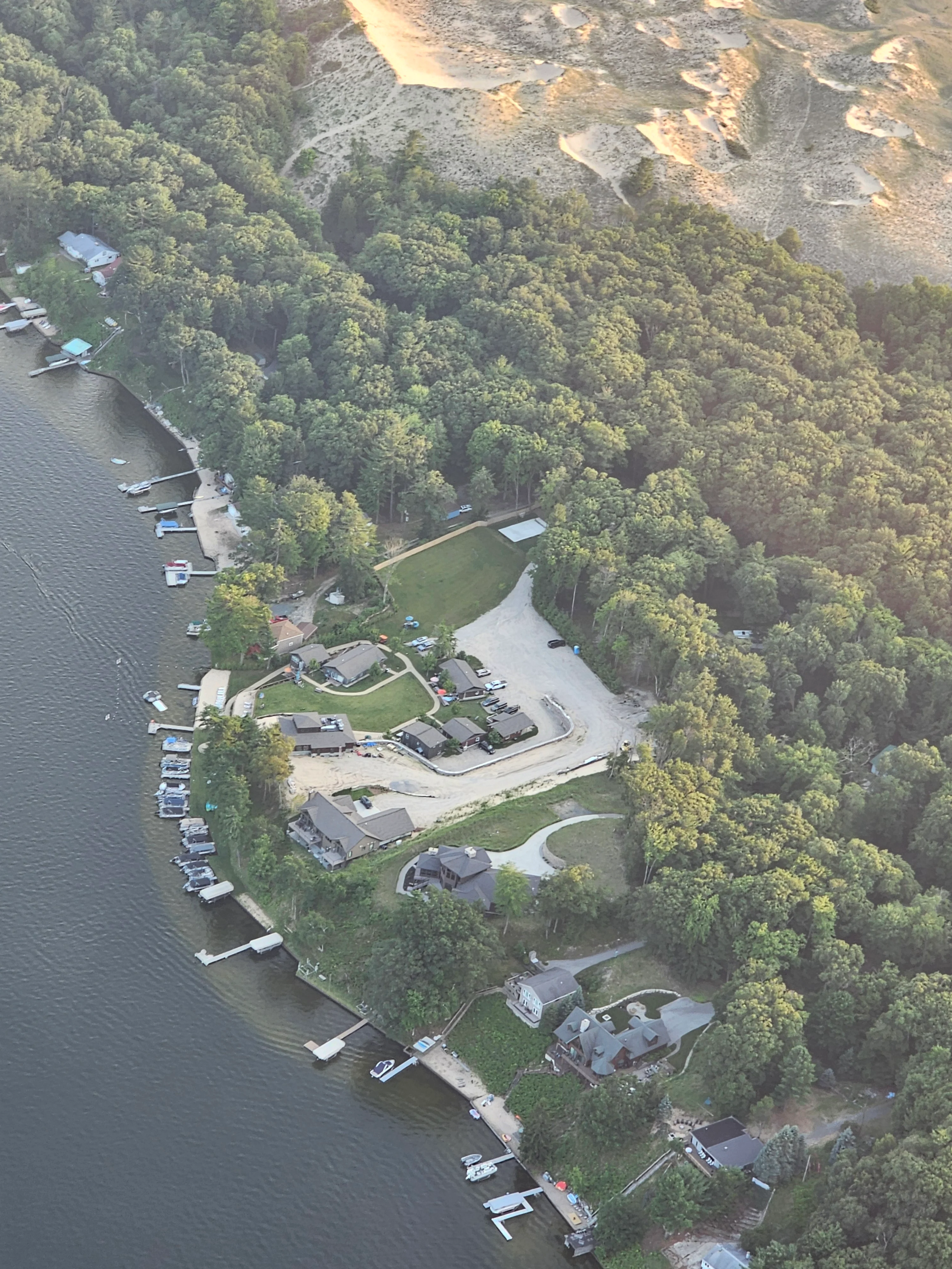 Aerial view of lakeside homes surrounded by lush greenery